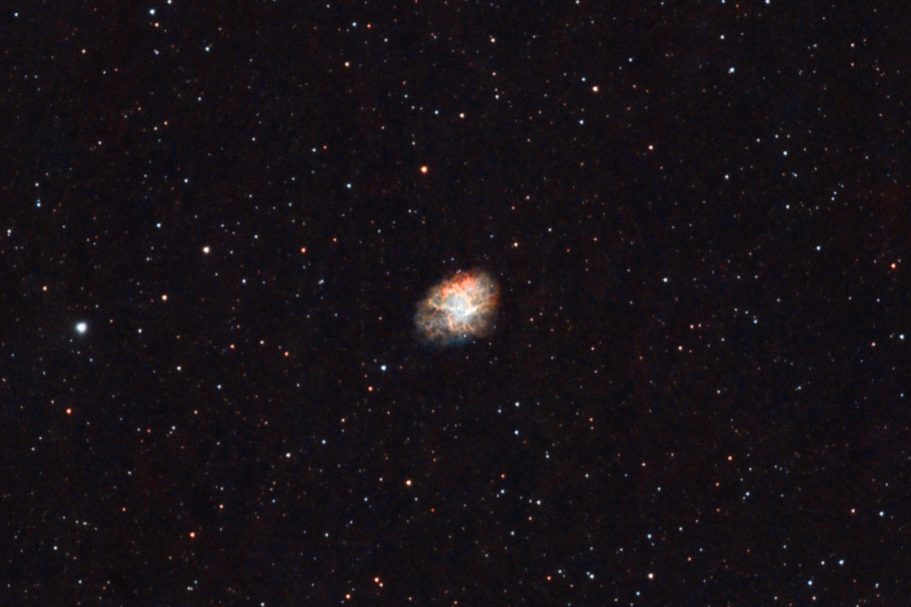 Ein verschwommener Nebel im Weltraum umgeben von vielen Sternen.