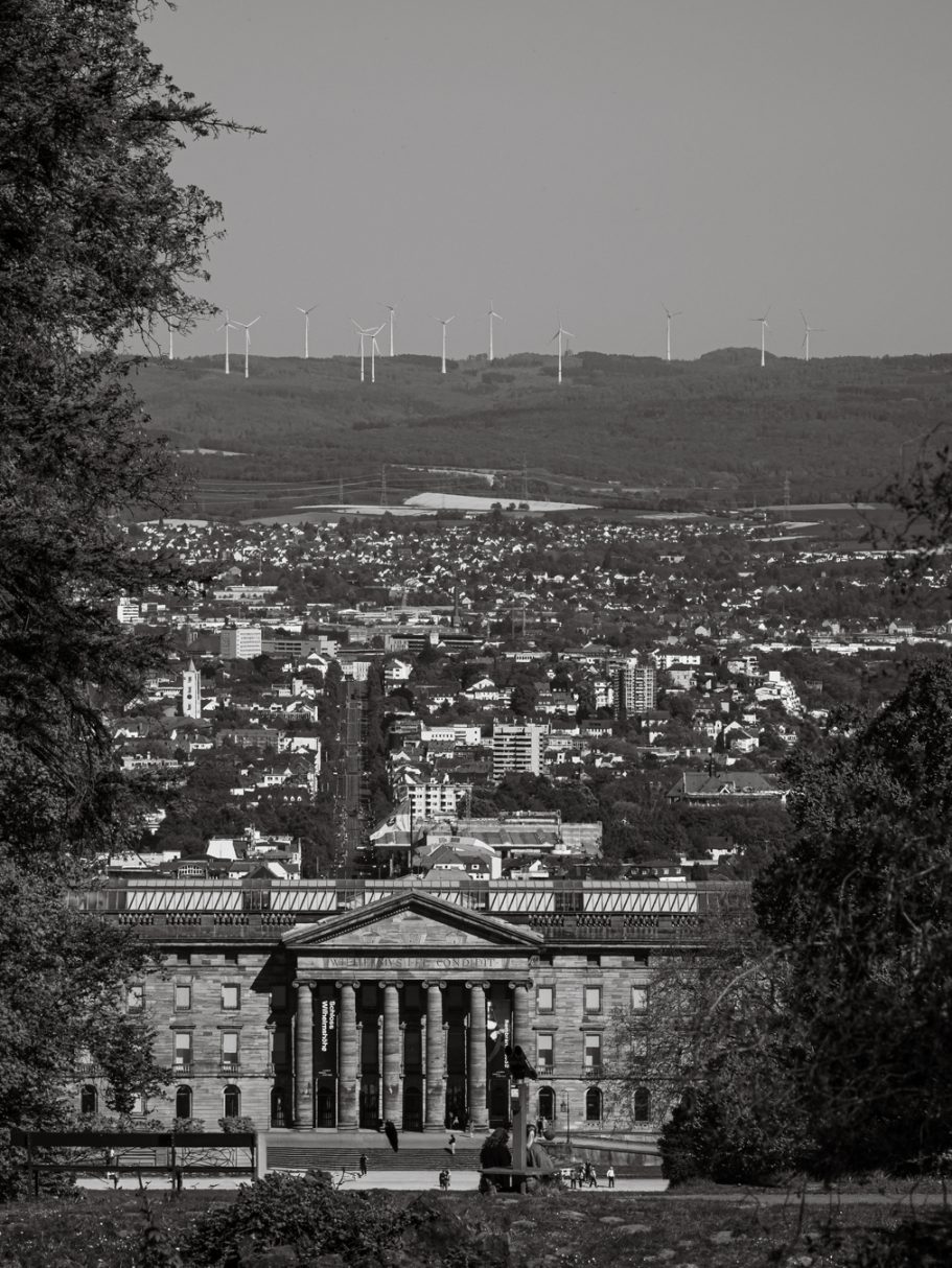 Blick auf ein historisches Gebäude mit Säulen und der Stadt im Hintergrund.