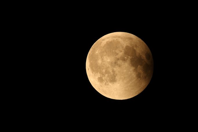 Ein großer, leuchtender Vollmond vor einem schwarzen Himmel.